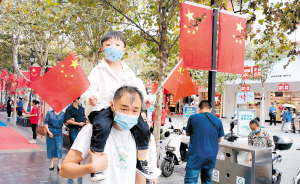   　　小朋友双手挥舞国旗欢度国庆。记者黄晓松摄